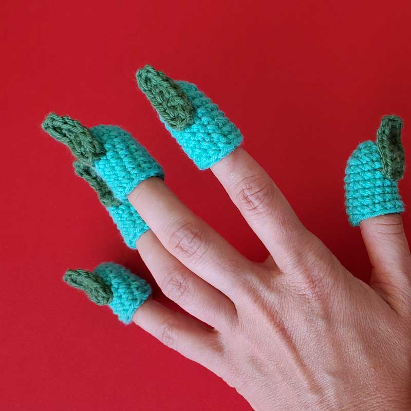 hand wearing crochet green fingertips and nails