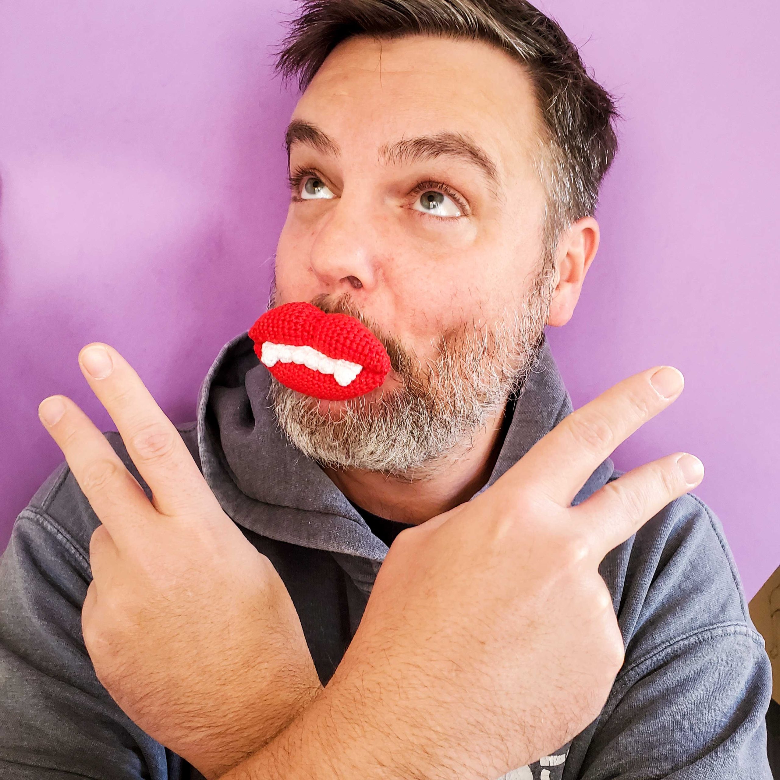 Man wearing whimsical wax crochet lips for a fun and playful look.