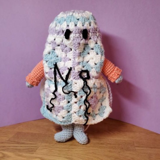 A crochet toy wearing a grannysquare ghost costume
