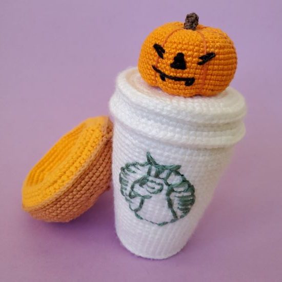 crocheted pumpkin on a crochet coffee cup
