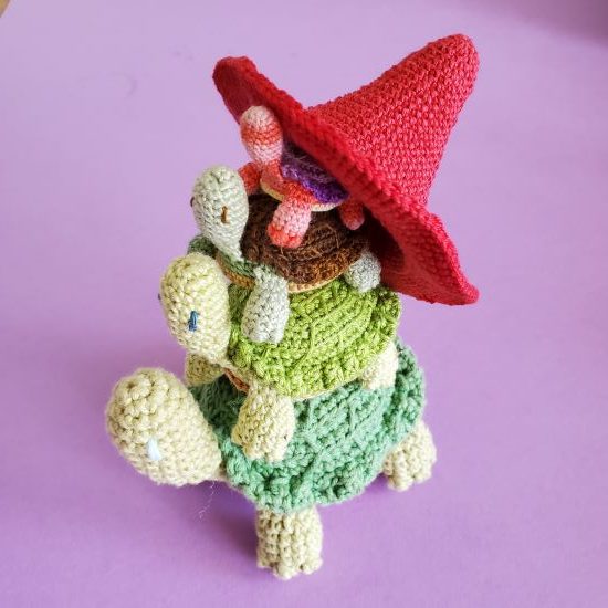 As stack of crochet turtles wearing a witches hat