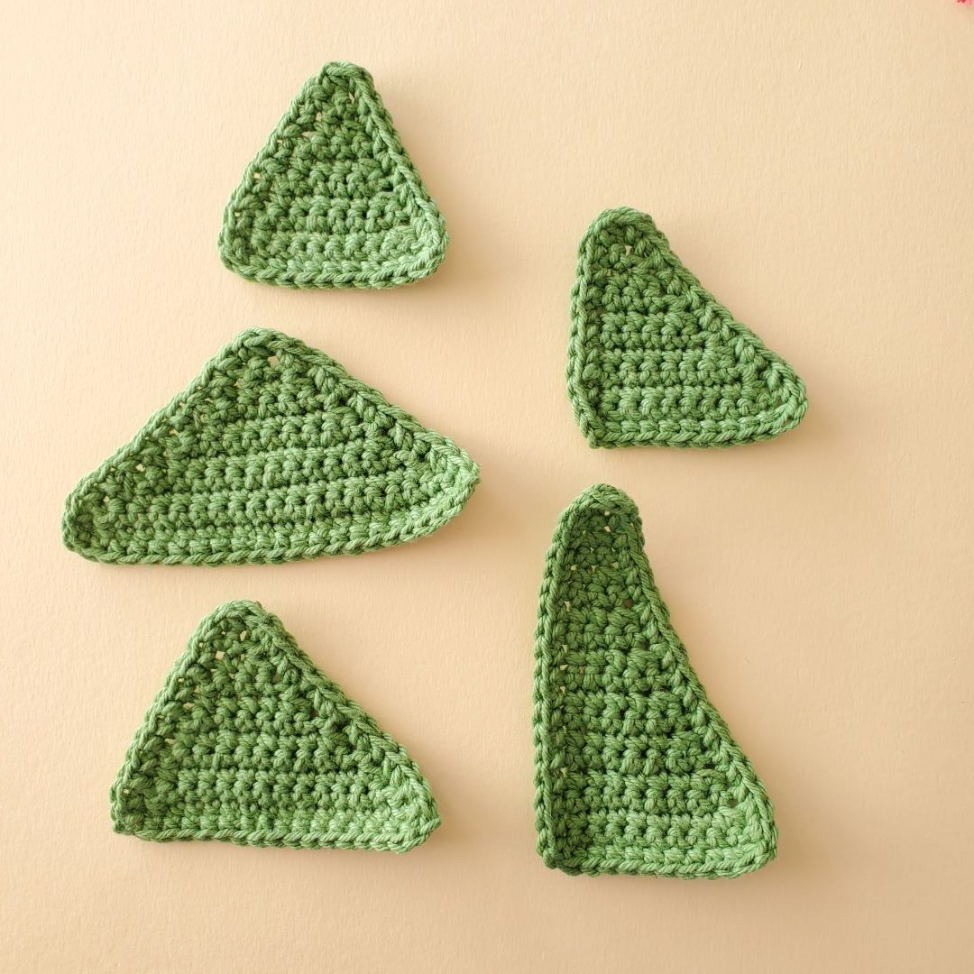 five green crochet triangles