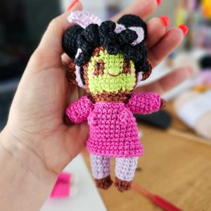 a crocheted doll in someone's hand
